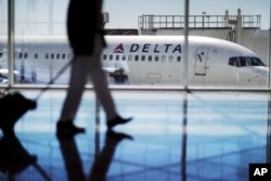 FILE - A Delta Air Lines jet sits at a gate at Hartsfield-Jackson Atlanta International Airport in Atlanta, Oct. 13, 2016. Georgia lawmakers punished Atlanta-based Delta Air Lines, March 1, 2018, for its decision to cut business ties with the National Rifle Association.