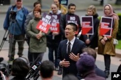 Hawaii Attorney General Doug Chin, center, talks to reporters outside a federal courthouse in Seattle, May 15, 2017.