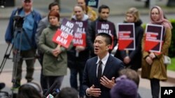 FILE - Hawaii Attorney General Doug Chin, center, talks to reporters outside a federal courthouse in Seattle, May 15, 2017. 