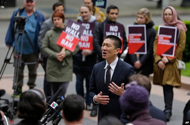 Hawaii Attorney General Doug Chin, center, talks to reporters outside a federal courthouse in Seattle, May 15, 2017.