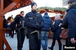 German police patrol with submachine guns at the Christmas market at Breitscheid square in Berlin, Dec. 30, 2016, following an attack by a truck which ploughed through a crowd at the market.