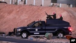 Jordanian security forces leave Swaqa prison, after the executions of Sajida al-Rishawi and Ziad al-Karbouly, two Iraqis linked to al-Qaida, south of the Jordan's capital, Amman, Feb. 4, 2015. (AP Photo/Raad Adayleh)
