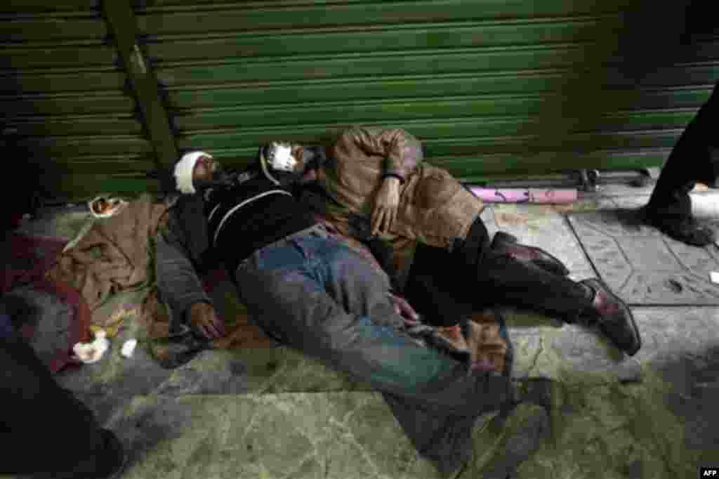 Anti-government demonstrators, wounded during clashes with pro-government protesters, wait to be treated at a makeshift medical triage station, near Tahrir square, the center of anti-government demonstrations, in Cairo, Egypt, Wednesday, Feb. 2, 2011. Th