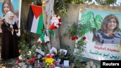 Seorang wanita Palestina mengambil gambar di lokasi di mana reporter Al Jazeera Shireen Abu Akleh ditembak mati dalam serangan Israel, di kota Jenin, Tepi Barat, wilayah Palestina yang diduduki Israel (foto: dok).