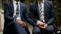 FILE -Clay Hamilton, left, and Adrian Coman, a U.S.-Romania a gay couple who got married in Belgium and seek legal recognition of their status in Romania hold hands in Bucharest, Romania, July 20, 2016. 