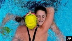 Kaylee McKeown, of Australia, is congratulated by teammate Emily Seebohm after winning the final of the women's 100-meter backstroke at the 2020 Summer Olympics, July 27, 2021, in Tokyo, Japan.