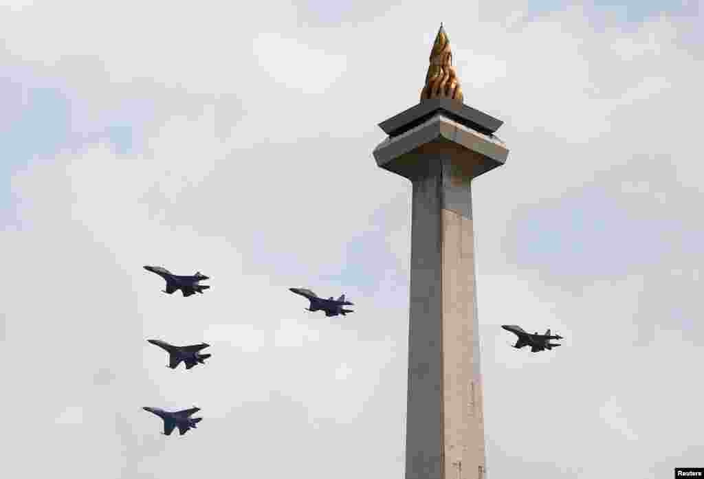 Pesawat jet tempur TNI Angkatan Udara terbang melintasi Monumen Nasional (Monas) untuk memperingati Ulang Tahun ke-73 Republik Indonesia, Jumat, 17 Agustus 2018. (Foto: Reuters)