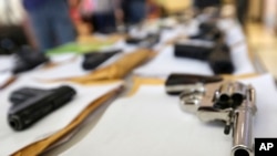 FILE - Chicago police display some of the thousands of illegal firearms that were confiscated in Chicago, July 7, 2014.