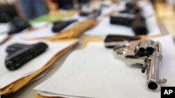 FILE - Chicago police display some of the thousands of illegal firearms they have confiscated in 2014 in their battle against gun violence in Chicago.