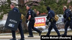 Polisi melakukan penyisiran di lapangan parkir supermarket King Soopers di Boulder, Colorado pasca insiden penembakan Senin sore (22/3). 