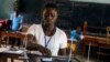 FILE - A woman casts her vote during during the runoff presidential elections, outside a polling station in Freetown, Sierra Leone, Saturday, March 31, 2018. 