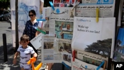 People walk past a shop selling newspapers in Beirut, Lebanon, Aug. 8, 2019. 