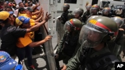 Manifestantes antichavistas discuten con militares de la Guardia Nacional Bolivariana en una protesta en Caracas, en abril de 2017. La Fundación Clooney para la Justicia investiga sobre crímenes de lesa humanidad por parte de autoridades venezolanas.