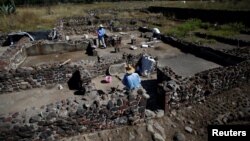 Men work at one of the multi-family apartment compounds at La Ventilla, one of the most extensively excavated neighborhoods in the ancient city of Teotihuacan, in San Juan Teotihuacan, on the outskirts of Mexico City, Mexico November 7, 2019. (REUTERS/Gustavo Graf )