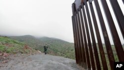 Border Patrol agent Vincent Pirro looks on near where a border wall ends that separates the cities of Tijuana, Mexico, and San Diego, California, Feb. 5, 2019, in San Diego. 