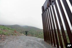 Border Patrol agent Vincent Pirro looks on near where a border wall ends that separates the cities of Tijuana, Mexico, and San Diego, Feb. 5, 2019, in San Diego.