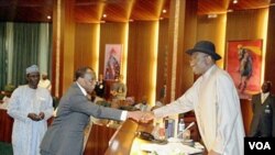 Pejabat Presiden Nigeria Goodluck Jonathan berjabat tangan dengan Menkeu Olusegun Aganga di Abuja.