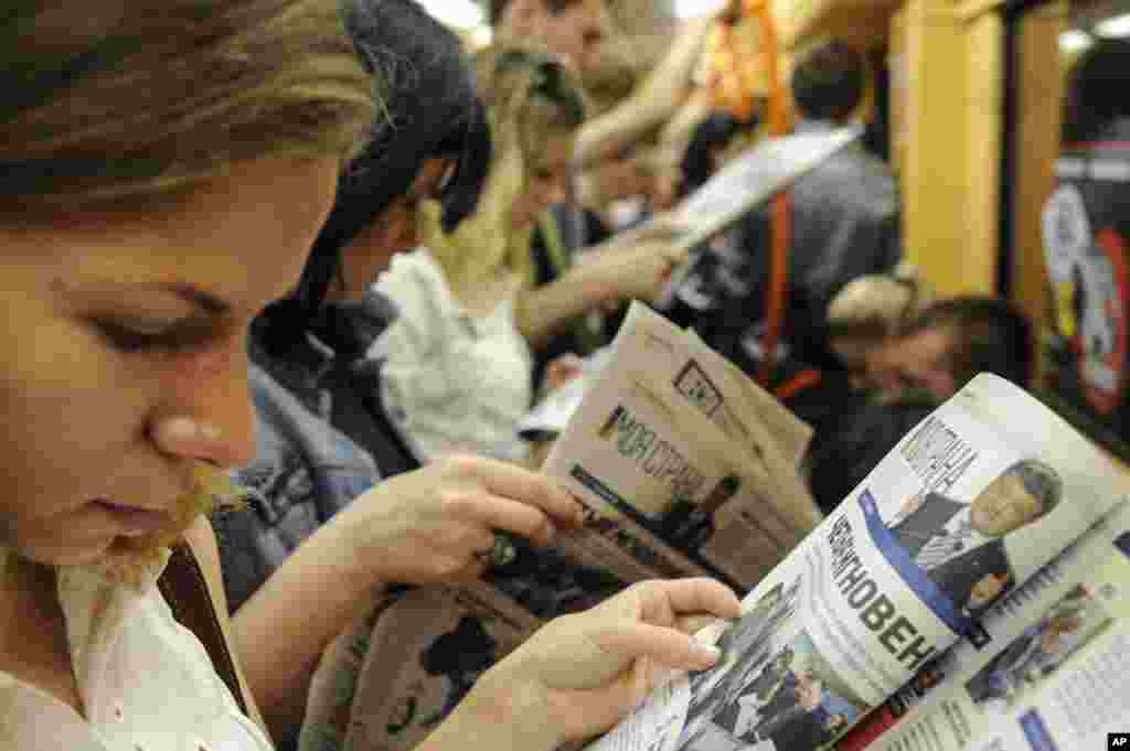 Ukrainians read newspapers at a metro station in Kyiv, May 26, 2014.