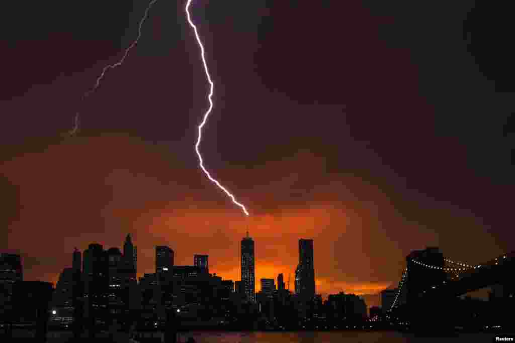 Lightning strikes One World Trade Center in Manhattan, New York, as the sun sets behind the city after a summer storm, July 2, 2014.