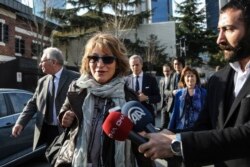 United Nations Special Rapporteur Agnes Callamard, surrounded by members of the media, walks around the Saudi Consulate, background, in Istanbul, Jan. 29, 2019. Callamard was investigating the death of Saudi journalist Jamal Khashoggi.