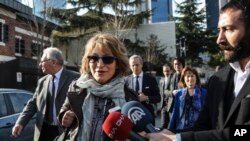 United Nations Special Rapporteur Agnes Callamard, surrounded by members of the media, walks around the Saudi Consulate, background, in Istanbul, Jan. 29, 2019. Callamard was investigating the death of Saudi journalist Jamal Khashoggi. 