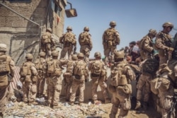 U.S. Marines with Special Purpose Marine Air-Ground Task Force - Crisis Response - Central Command assist with security at an Evacuation Control Checkpoint (ECC) during an evacuation at Hamid Karzai International Airport, Kabul, Afghanistan.