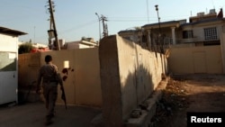 FILE - A security guard walks outside the Al-Jazeera building in Baghdad April 28, 2013. Iraq’s media commission ordered the Qatar-based broadcaster’s Baghdad bureau closed for one year, citing ‘continuing violations’ of media regulations.