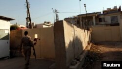 FILE - A security guard walks outside the Al-Jazeera building in Baghdad April 28, 2013. Iraq’s media commission on Thursday ordered the Qatar-based broadcaster’s Baghdad bureau closed for one year, citing ‘continuing violations’ of rules.
