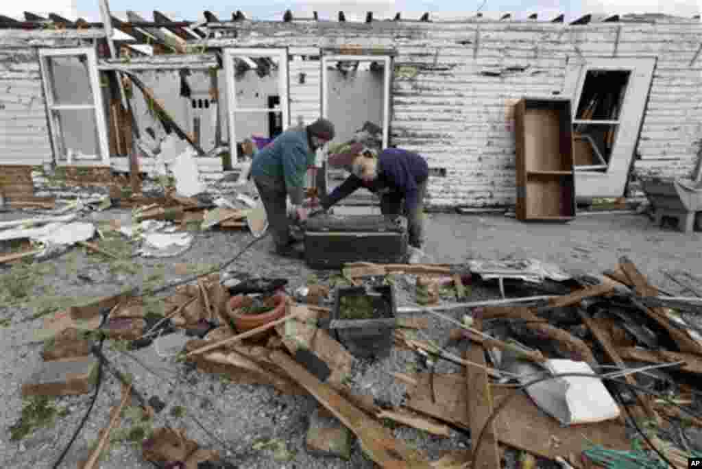 Daniel Ward, left, and his wife Peggy Ward carry a box from their home destroyed by tornado in Henryville, Ind., Sunday, March 4, 2012.