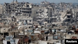 FILE - Damaged buildings are seen in the besieged area of Homs, Syria.