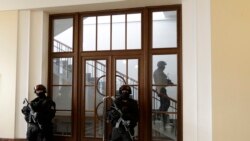 FILE - A prison guard walks outside a courtroom during an appeal by Yevgeniy Nikulin from Russia who faces charges of hacking computers of American companies, Prague, Czech Republic, Nov. 24, 2017.