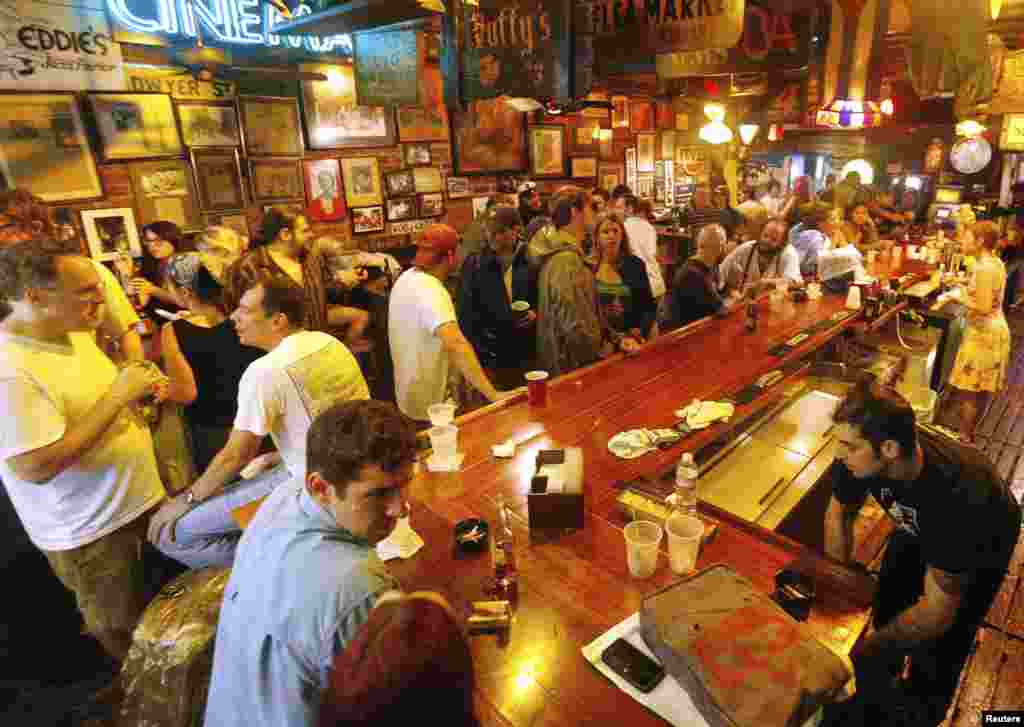 People gather in a French Quarter bar as Tropical Storm Isaac passes through New Orleans, Louisiana, August 29, 2012. 