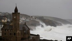 FILE - Powerful waves break on the shoreline around the small port of Porthleven, southwest England, Feb. 16, 2020. 