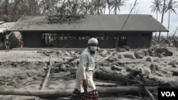 Seorang pria melewati sebuah gedung sekolah yang hancur di Cangkringan akibat letusan Gunung Merapi, Oktober lalu.