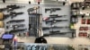 FILE - Weapons hang in a gun shop, Feb. 19, 2021, in Salem, Ore. 