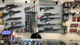 FILE - Weapons hang in a gun shop, Feb. 19, 2021, in Salem, Ore. 