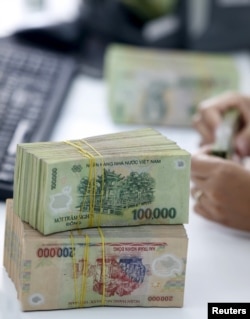 A bank employee checks Vietnamese dong banknotes at a bank in Vinh Yen city, Vietnam, August 19, 2015.