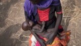 Adel Bol, 20, cradles as she her 10-month-old daughter Akir Mayen at a food distribution site in Malualkuel in the Northern Bahr el Ghazal region of South Sudan.