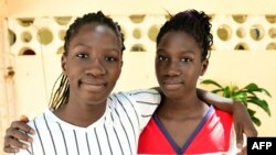 Aminata et Rama Diaw, les jumelles de 13 ans, devant leur maison à Yeumbeul, Sénégal, le 18 août 2021.