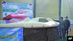 在這張12月8日公開但沒有標明日期的照片中﹐一名伊朗革命衛隊隊員指向一架伊朗所說的美國RQ-170無人偵察機