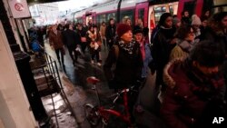 Commuters walk to get on a train at the Gare Saint Lazare station in Paris, France, Dec. 16, 2019.