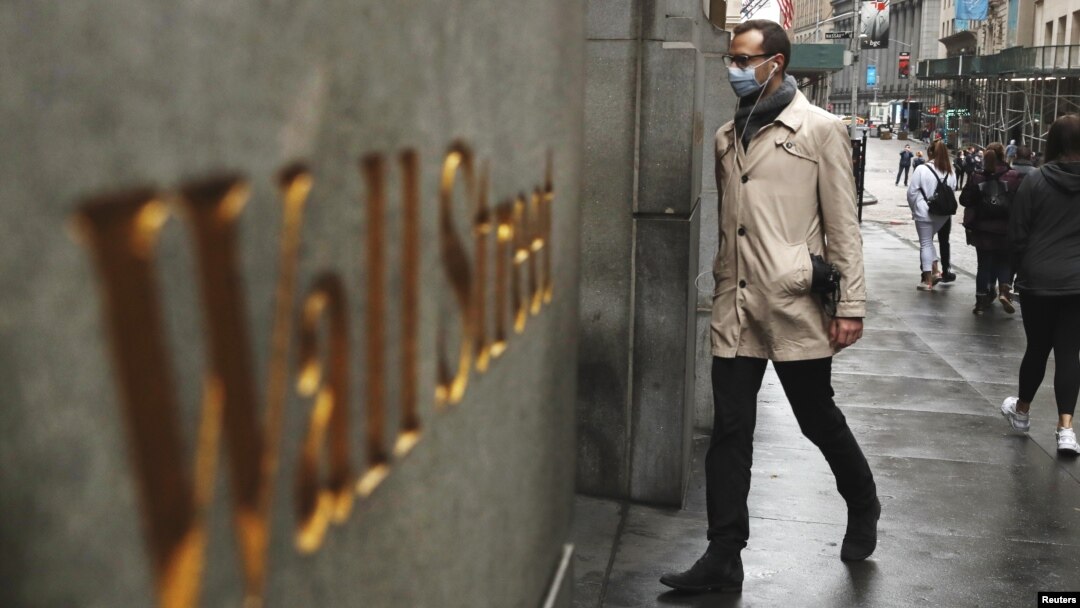 Seorang pria mengenakan masker berjalan di Wall Street di tengah wabah virus corona di Kota New York, 13 Maret 2020. (Foto: Reuters)