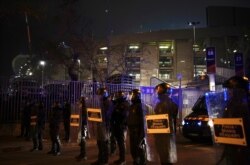 Police officers bar the way to Catalan pro-independence demonstrators during a protest outside the Camp Nou stadium ahead of a Spanish La Liga soccer match between Barcelona and Real Madrid in Barcelona, Dec. 18, 2019.