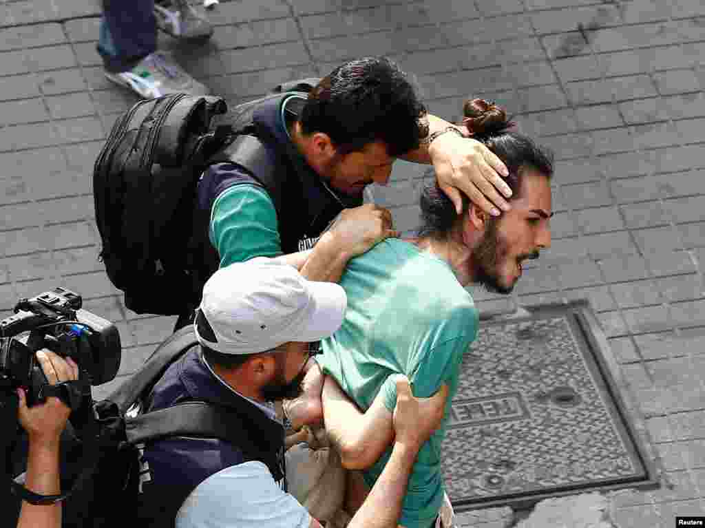 Plainclothes police officers detain LGBT rights activists as they gather for a pride parade in Istanbul, Turkey.