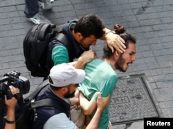 FILE - Plainclothes police officers detain LGBT rights activists as they try to gather for a pride parade, which was banned by the governorship, in Istanbul, Turkey, June 26, 2016.