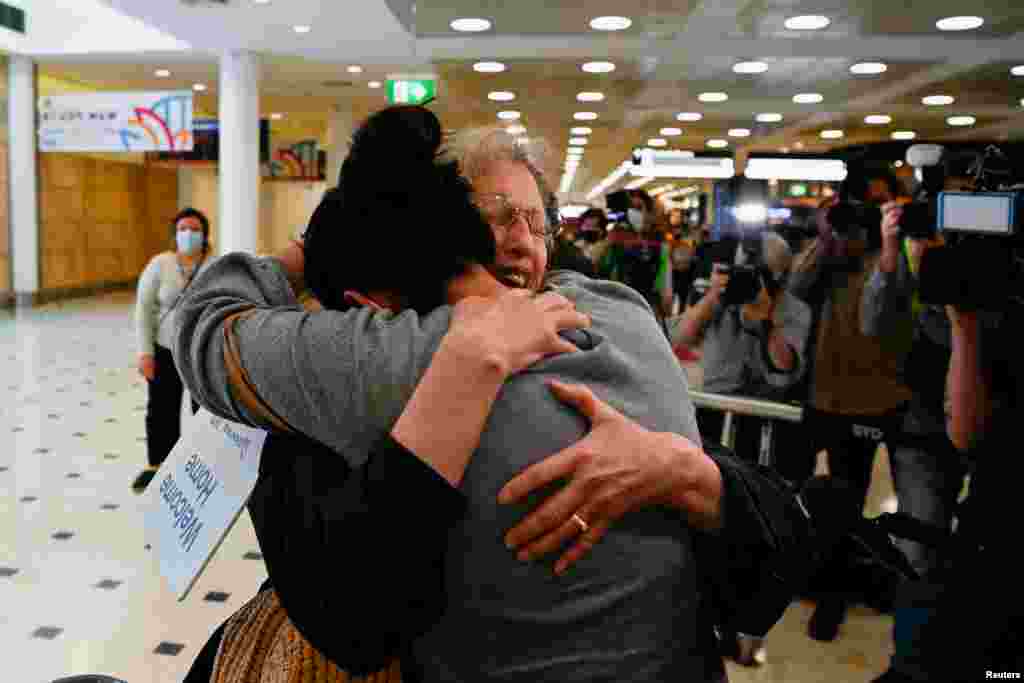 An international traveller is hugged as she arrives at Sydney Airport in the wake of COVID-19 border restrictions easing, with fully vaccinated Australians being permitted into Sydney from overseas without quarantine for the first time since March 2020.