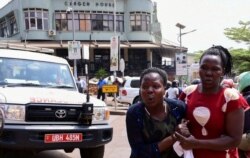 Des passantes tentent de s'éloigner de la scène d'une explosion à Kampala, le 16 novembre 2021.