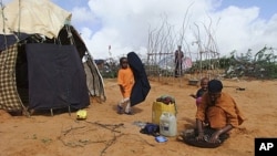 A Somali woman from southern Somalia, washes clothes outside her makeshift shelter in a refugee camp in Mogadishu, Somalia, August 4, 2011