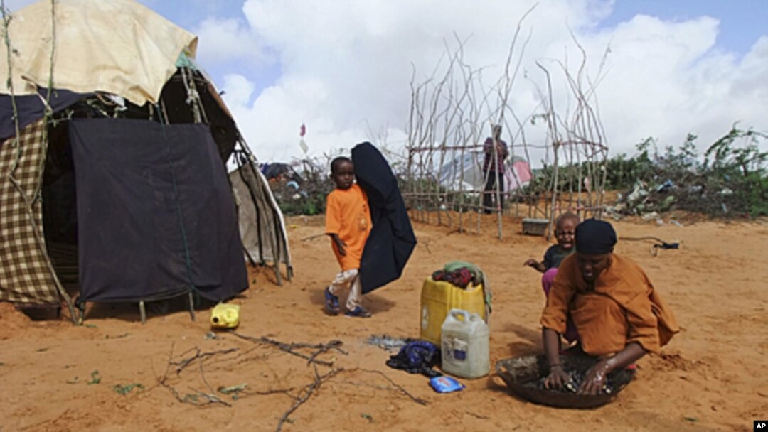 A Somali woman from southern Somalia, washes clothes outside her makeshift shelter in a refugee camp in Mogadishu, Somalia, August 4, 2011