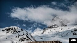 A flock of sheep goes down the road on Col du Glandon, near Saint Colomban Des Villards, a mountain pass in the Dauphine Alps in Savoie, France.